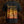 A black short-sleeve Brodequin band t-shirt showing the back side with a large graphic print. The print features the text 'Harbinger of Woe' in a gothic font above a detailed, warm-toned illustration in yellow, orange, and brown hues.