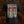 Black short-sleeve Brodequin band t-shirt shown from the back, featuring a large graphic print with the text 'Perpetuation of Suffering' in a gothic font over a dark, distressed illustration in beige, red, and black.