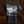 A black short-sleeve t-shirt featuring a large graphic print of the band Brodequin on the chest, with a grayscale historical painting in the center and a circular sleeve print.