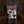 A black Inveracity short-sleeve graphic t-shirt featuring the band name 'Inveracity' in a jagged red font above a detailed graphic print of a woman with blonde hair and a knife, set against a dark textured background.