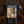 A black short-sleeve graphic Liturgy band t-shirt featuring the band name 'Liturgy' in a stylized white font above a large, detailed multicolor artwork print. A white symbol is printed on the left sleeve.